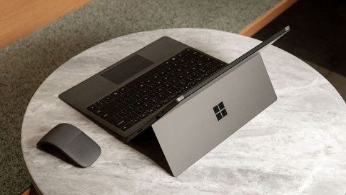 Surface Pro 7 in Matte Black with Surface Arc Mouse on a small table