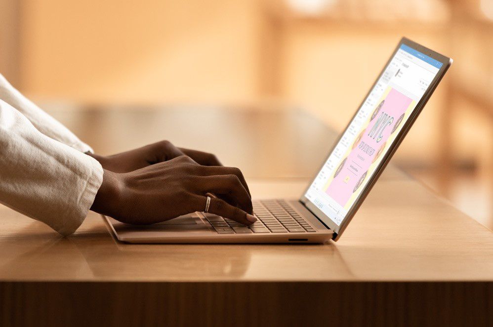 A woman types on the large keyboard of Surface Laptop 3
