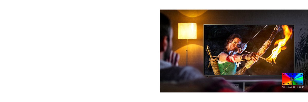 Un bărbat stă pe canapea si urmăreste un film de actiune. Fata de la televizor tine în mână un arc întins la maximum si o săgeată.