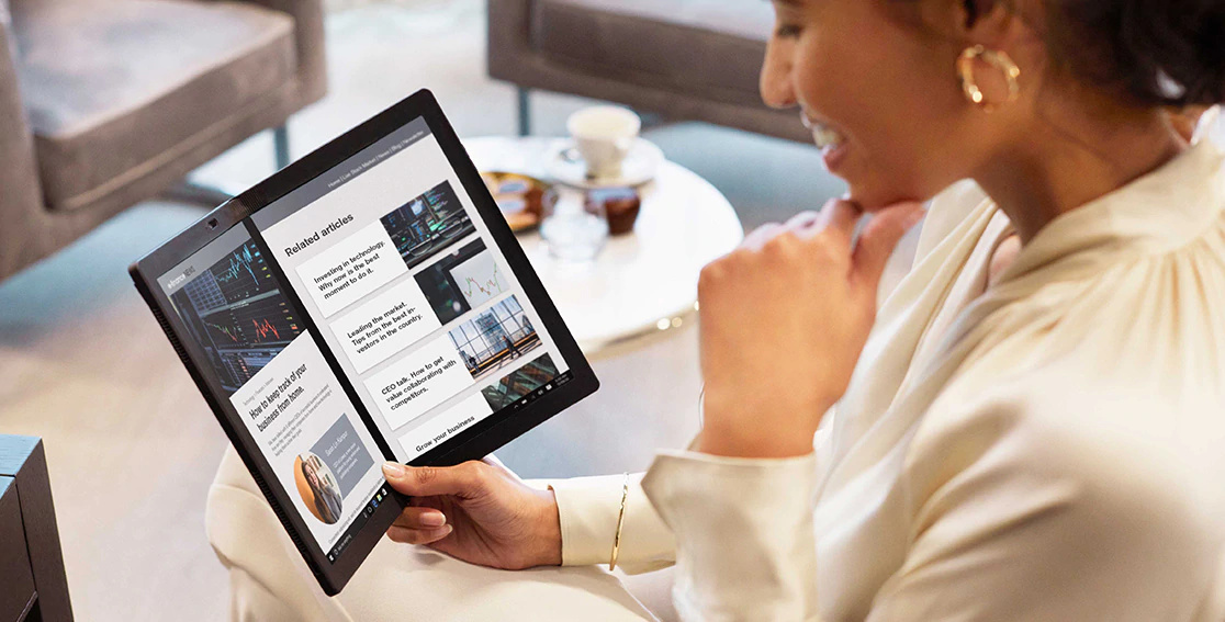 Woman holding Lenovo X1 Fold slightly closed in landscape